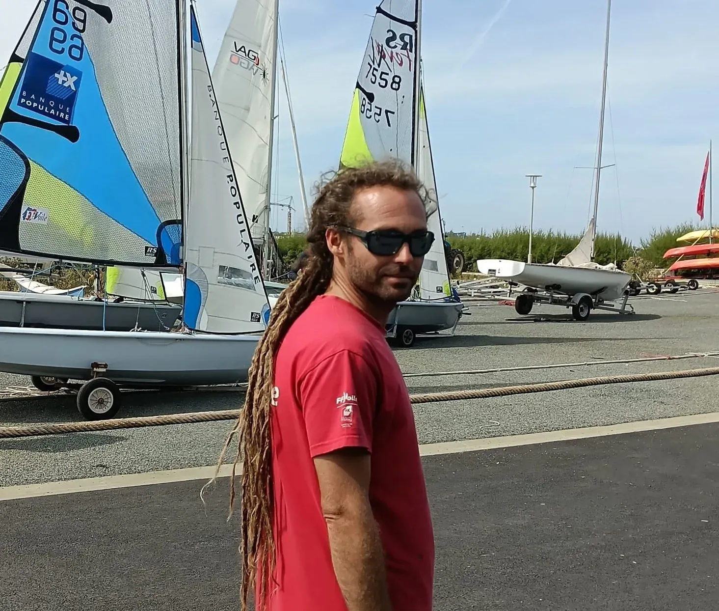 Kevin sur le terre-plein du centre, devant les dériveurs du club